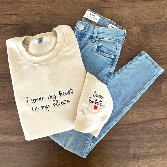 I Wear My Heart On My Sleeve, Embroidered Custom Mama Shirt With Kids Names, Pregnancy Reveal Hoodie Gift For New Mom, Mother’s Day Gift – Fanshubus.com